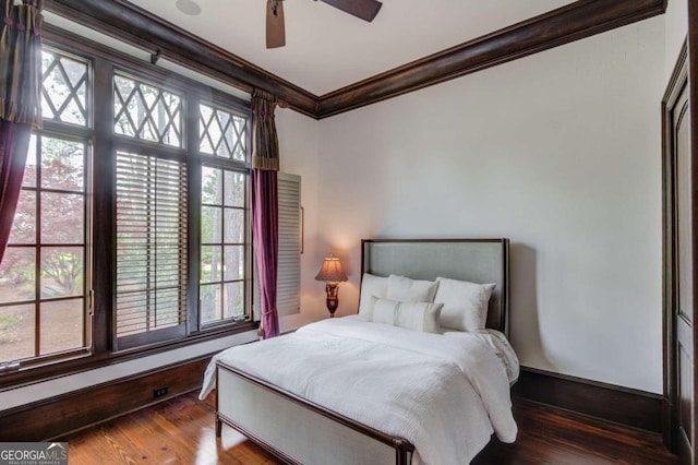 bedroom featuring ceiling fan, crown molding, and dark wood-type flooring