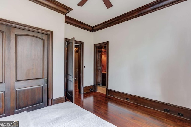 unfurnished bedroom with ornamental molding, dark hardwood / wood-style flooring, and ceiling fan