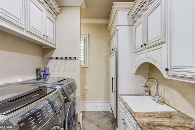 laundry room featuring light tile flooring, cabinets, crown molding, independent washer and dryer, and sink