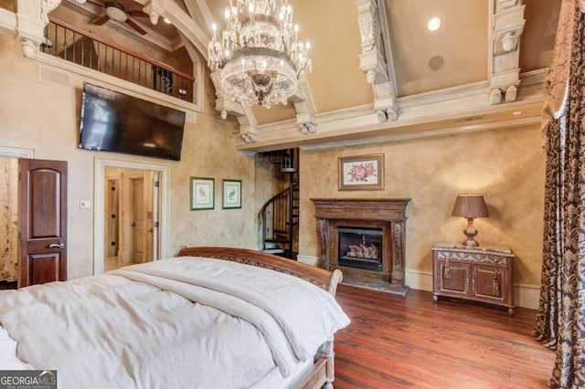 bedroom featuring a notable chandelier, dark hardwood / wood-style floors, beamed ceiling, and a towering ceiling