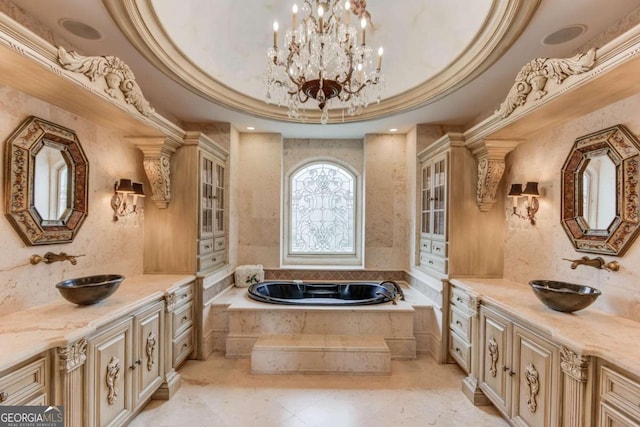 bathroom featuring an inviting chandelier, tile floors, tiled tub, vanity, and a tray ceiling