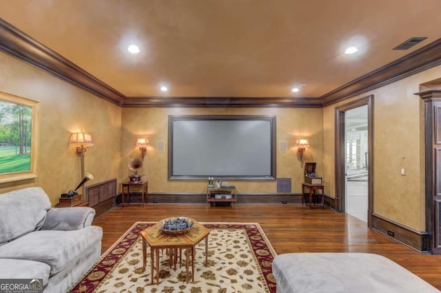 cinema with dark hardwood / wood-style floors and ornamental molding