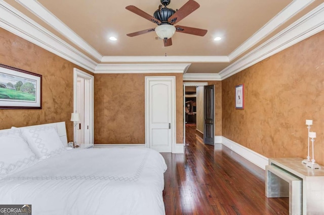 bedroom with crown molding, dark hardwood / wood-style floors, a raised ceiling, and ceiling fan