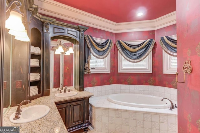 bathroom featuring tiled bath, a healthy amount of sunlight, and double sink vanity