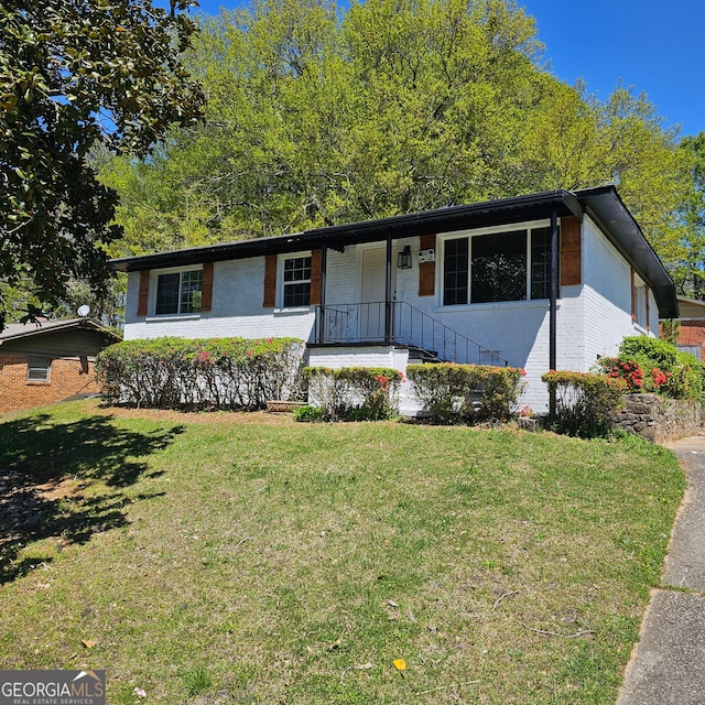 ranch-style house featuring covered porch and a front lawn