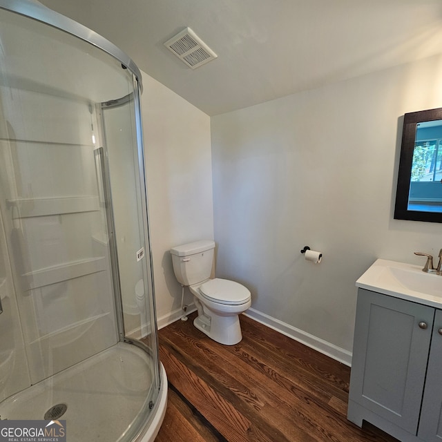 bathroom featuring toilet, a shower with door, wood-type flooring, and vanity