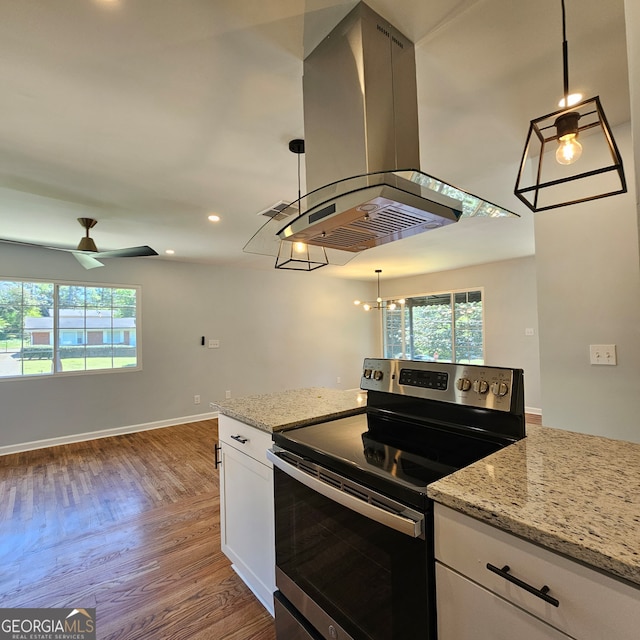 kitchen featuring island range hood, decorative light fixtures, stainless steel electric range oven, and white cabinetry