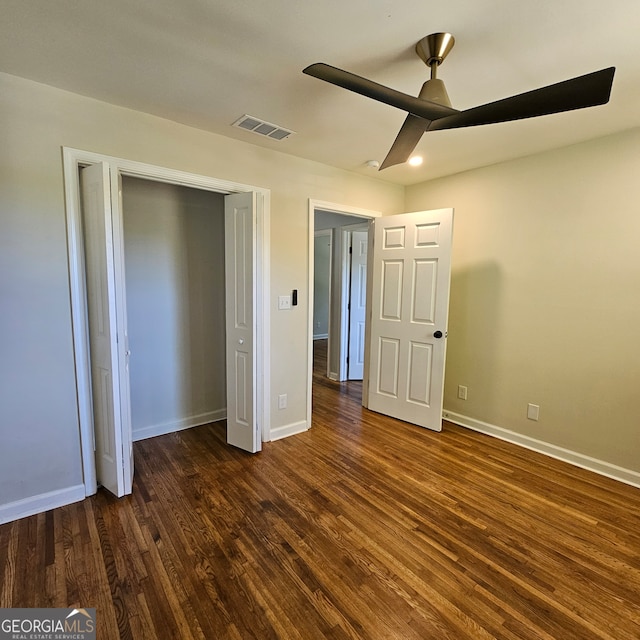 unfurnished bedroom with a closet, dark hardwood / wood-style floors, and ceiling fan