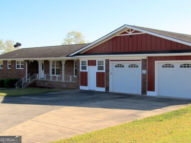 ranch-style home with a porch and a garage