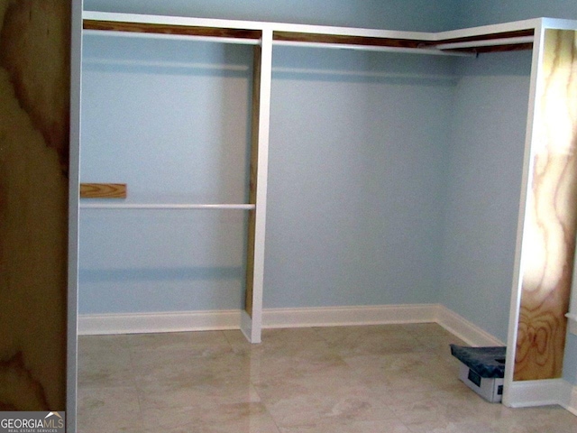 walk in closet with light tile flooring