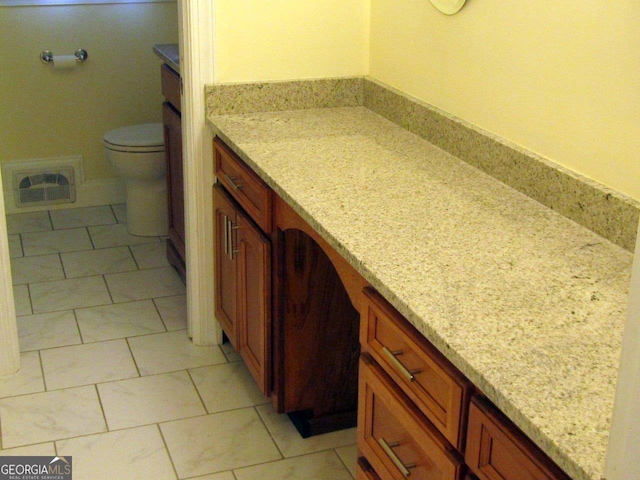 bathroom with tile floors, toilet, and vanity