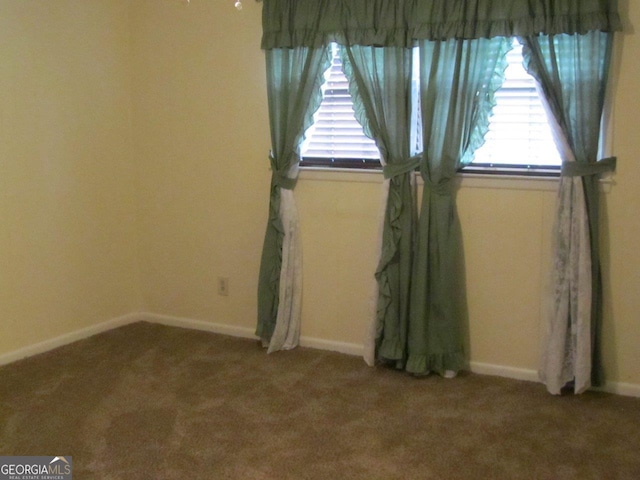 spare room with dark carpet