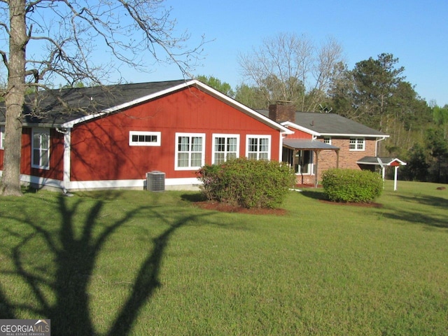 view of property exterior with central AC and a yard