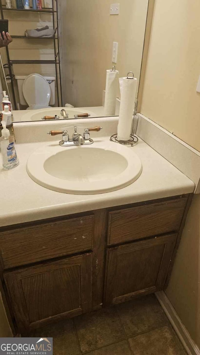 bathroom featuring tile patterned flooring, vanity, and toilet