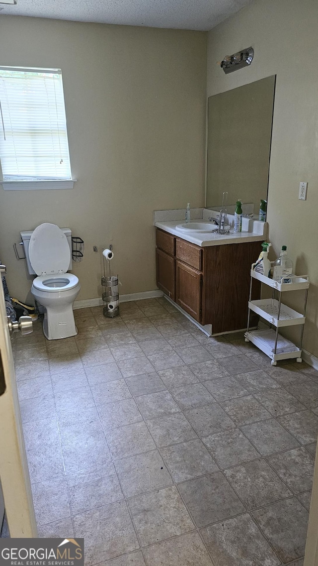 bathroom featuring vanity, a textured ceiling, and toilet