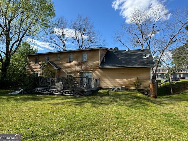 rear view of property featuring a lawn and a wooden deck