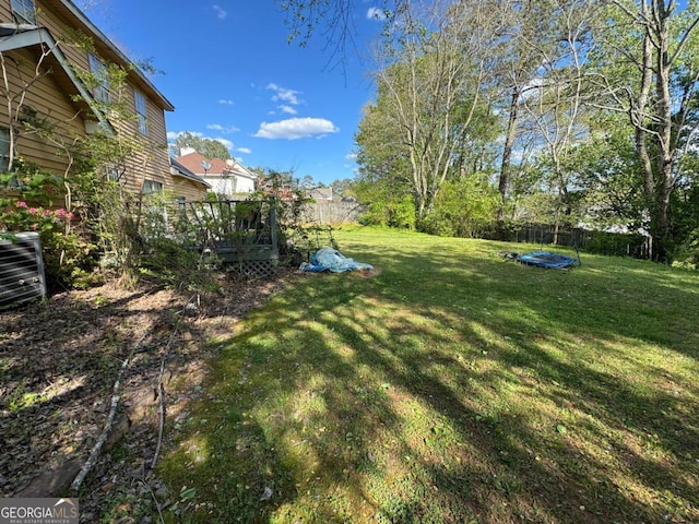 view of yard with a deck and a trampoline