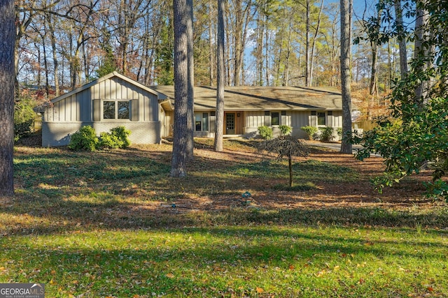 view of front of property featuring brick siding, board and batten siding, and a front lawn