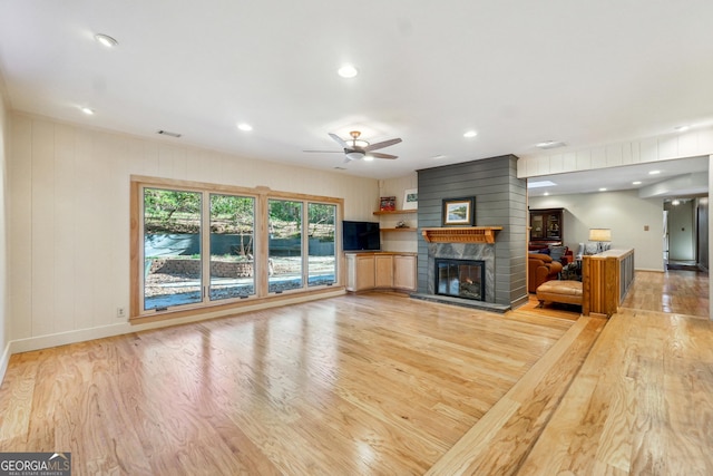 unfurnished living room with a fireplace, light hardwood / wood-style floors, and ceiling fan