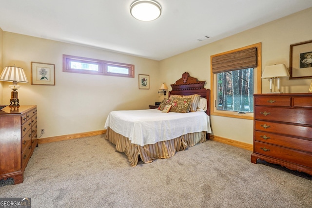 bedroom with light colored carpet and multiple windows