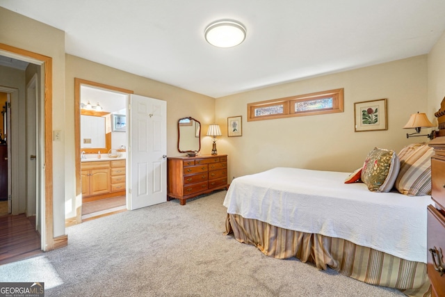 bedroom with light colored carpet and ensuite bath