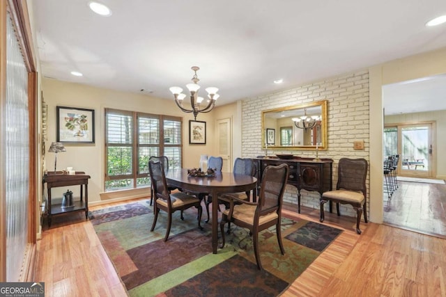 dining room with hardwood / wood-style floors and an inviting chandelier