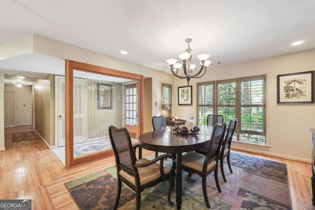 dining area featuring ceiling fan with notable chandelier and light wood-type flooring