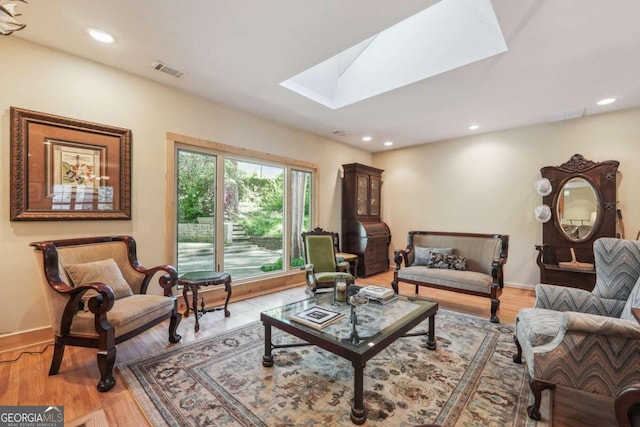 sitting room featuring hardwood / wood-style flooring and a skylight