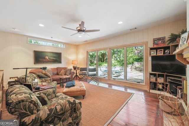 living room featuring wood-type flooring and ceiling fan