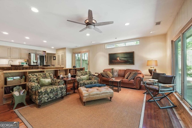 living room with plenty of natural light, ceiling fan, and wood-type flooring