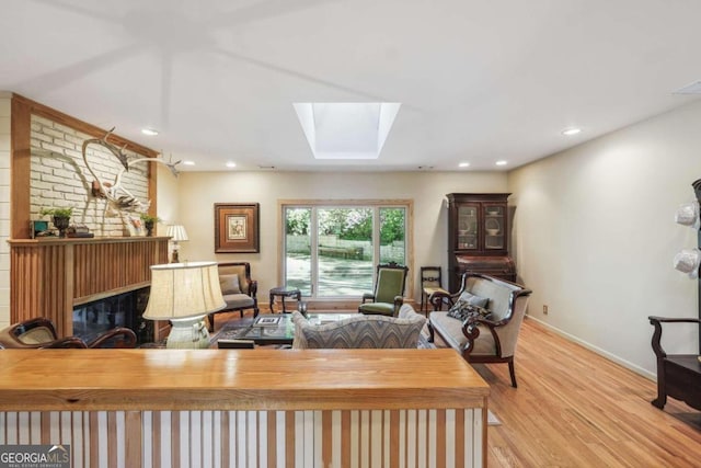 living room with light hardwood / wood-style floors and a skylight