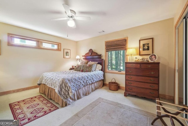 carpeted bedroom featuring a closet, multiple windows, and ceiling fan