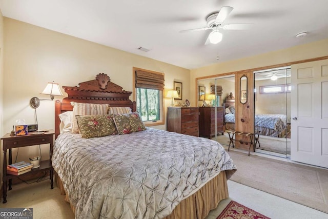 carpeted bedroom featuring ceiling fan and two closets