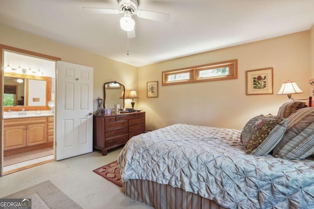 bedroom with light carpet, multiple windows, ensuite bathroom, and ceiling fan