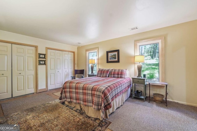 bedroom featuring carpet flooring and two closets