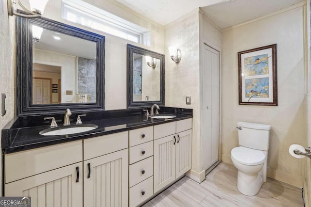 bathroom with wood-type flooring, vanity, toilet, and crown molding