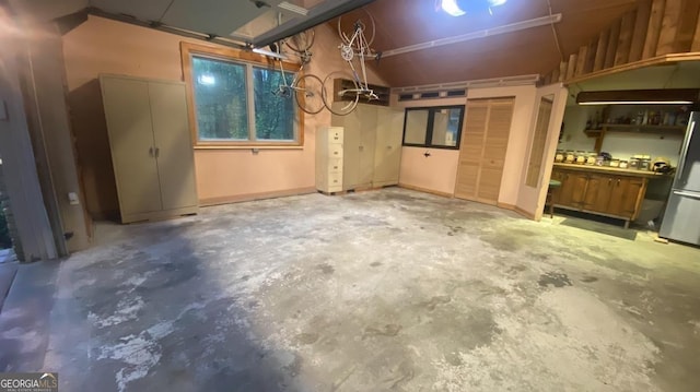 basement with stainless steel fridge and a workshop area