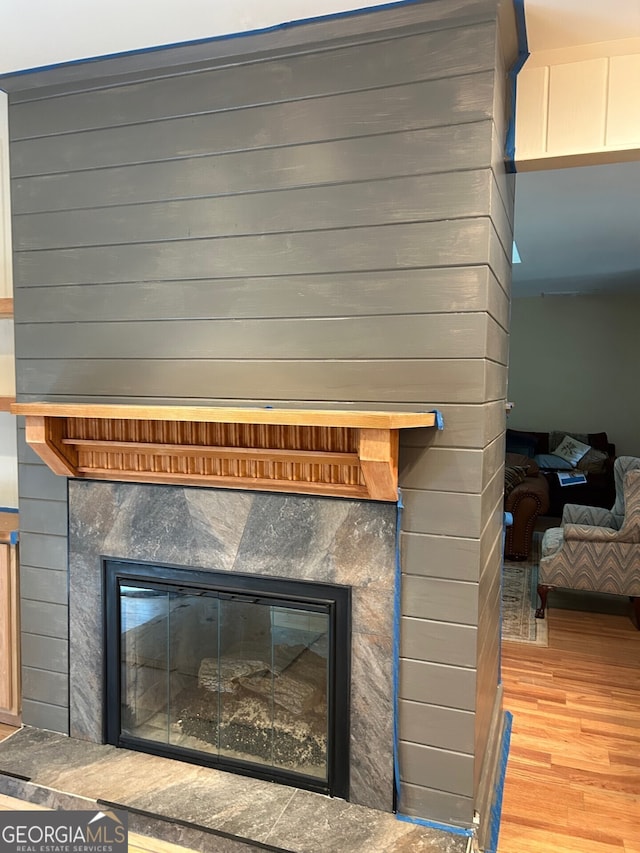 details with wood-type flooring, a fireplace, and wooden walls