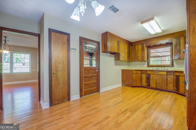 kitchen featuring a chandelier, light hardwood / wood-style floors, and decorative light fixtures