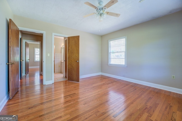 unfurnished bedroom featuring light hardwood / wood-style flooring, ceiling fan, and a textured ceiling