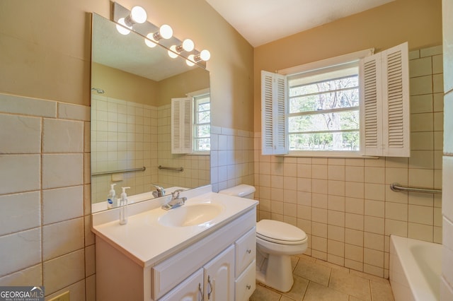 bathroom with tile walls, large vanity, toilet, and tile flooring