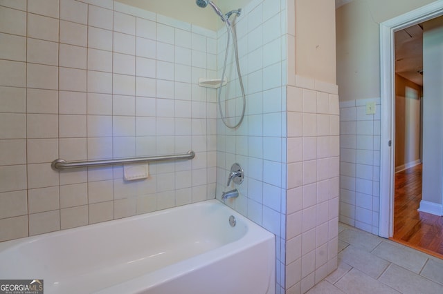 bathroom featuring tiled shower / bath, wood-type flooring, and tile walls