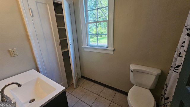 bathroom featuring tile flooring, vanity, and toilet