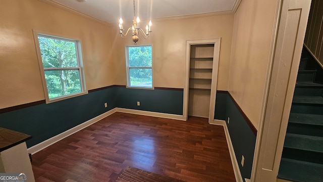 unfurnished room with ornamental molding, a healthy amount of sunlight, dark hardwood / wood-style flooring, and a notable chandelier