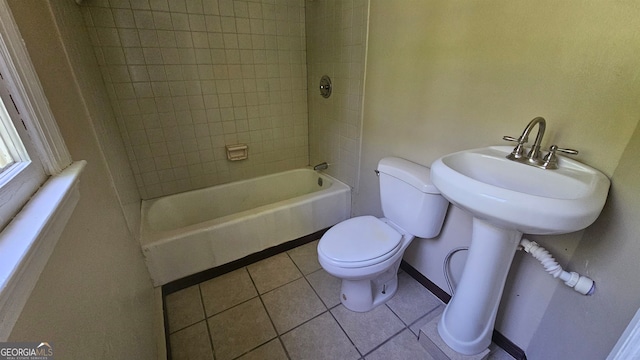 bathroom with tiled shower / bath, toilet, and tile floors