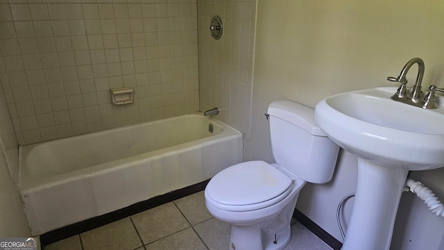 bathroom featuring tile floors, tiled shower / bath, and toilet