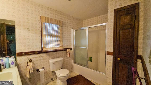 bathroom featuring tile walls, toilet, and a textured ceiling