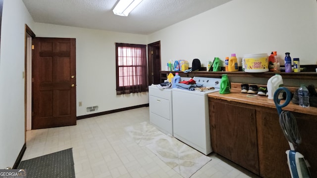 laundry room with light tile floors, a textured ceiling, and separate washer and dryer