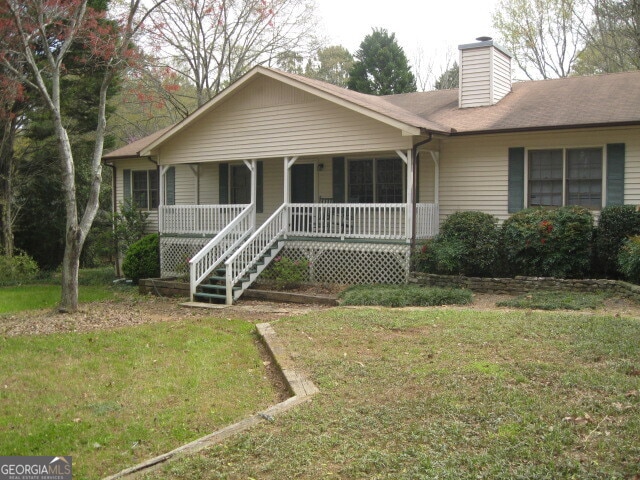 single story home with covered porch and a front lawn