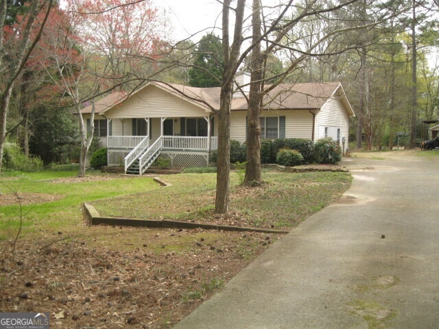 single story home featuring a front lawn and covered porch